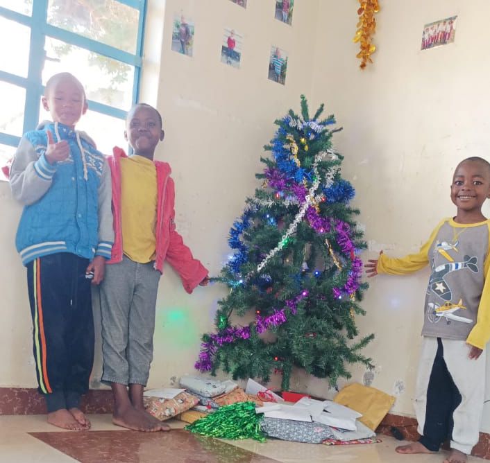 Die Kinder des Waisenhauses in Afrika vor dem Weihnachtsbaum